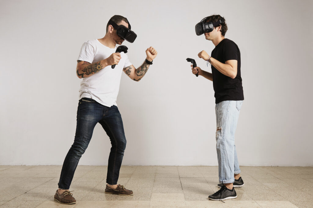man white unlabeled t shirt with bear tattoos man black unlabeled t shirt wearing vr headsets fight room with white walls